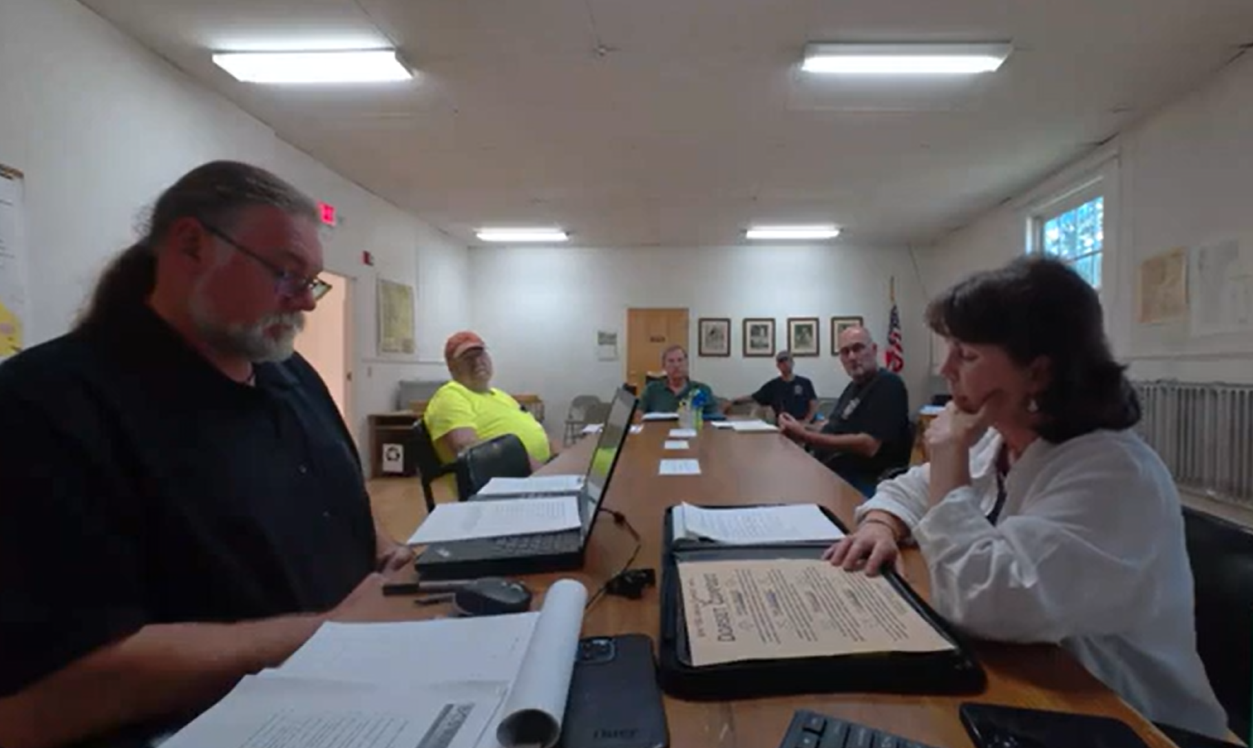 board and staff members sitting at a table during a meeting.
